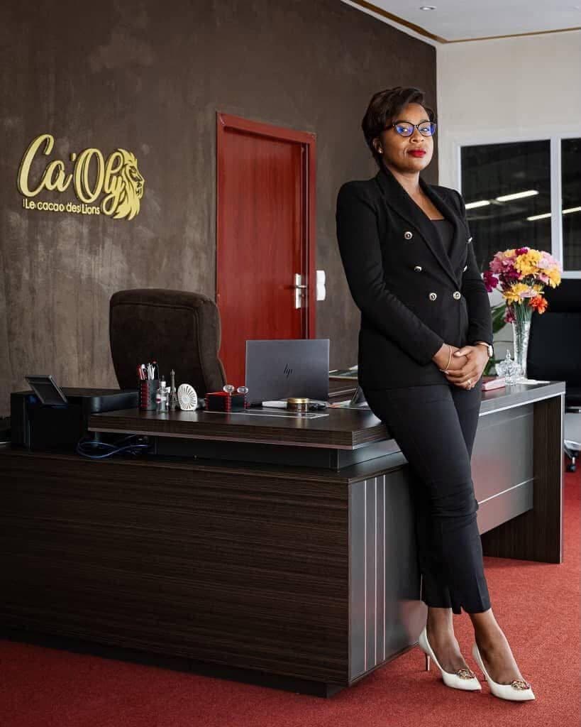 Lisette Claudia TAME NJAMBE dans son bureau, devant l’enseigne CA’OLY, le cacao des Lions